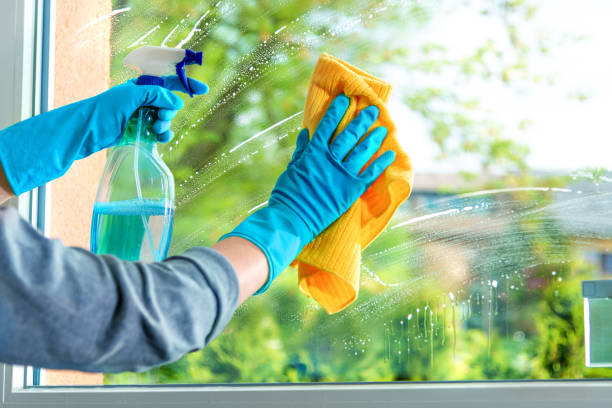 Über uns cleaning window pane with detergent, spring cleaning concept